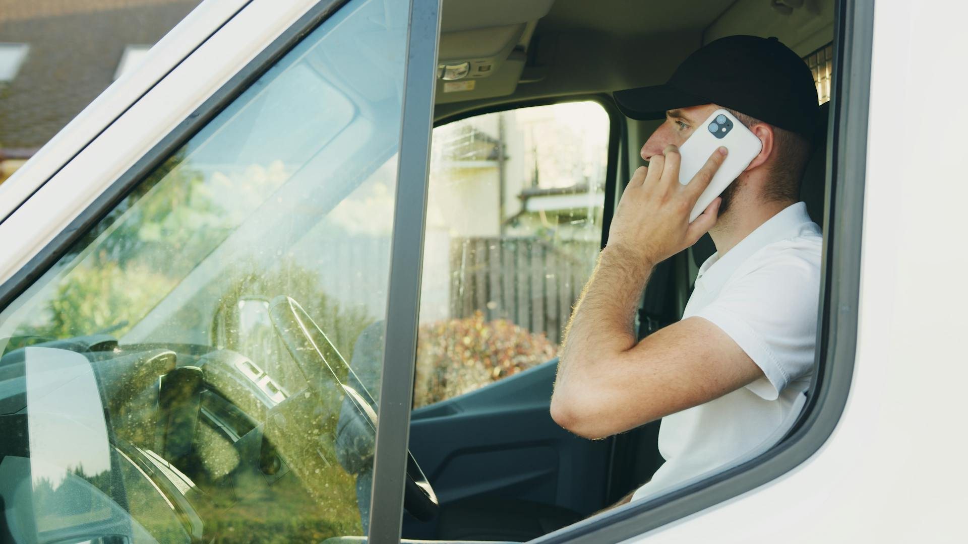 Trucker driver operating voice dispatch hands-free desde el cab mientras conduce en highway
